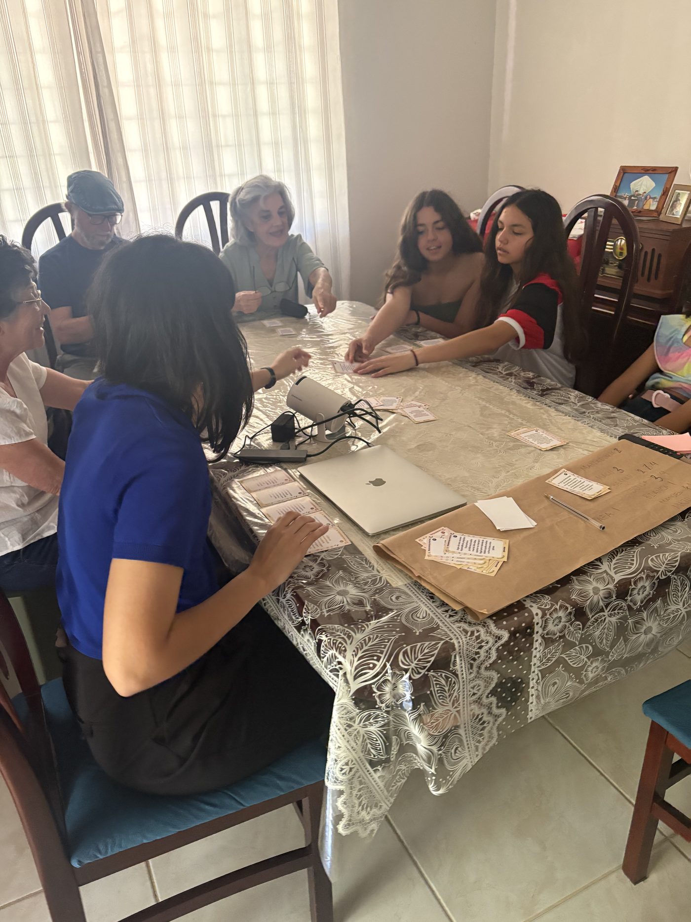 Meninas e mulheres ao redor de uma mesa jogando cartas sobre violência digital